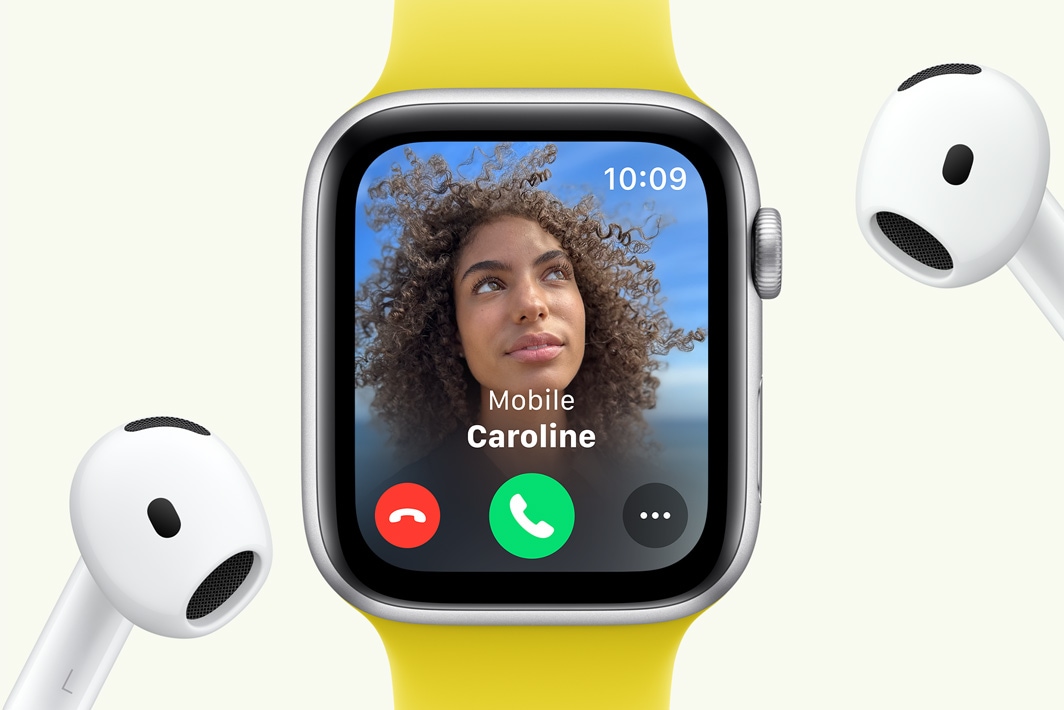 Το Apple Watch SE εμφανίζει μια εισερχόμενη κλήση, δίπλα σε ένα ζευγάρι AirPods.