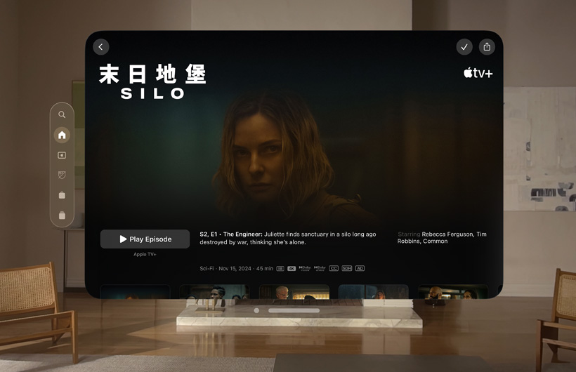 The Apple TV experience of Apple Vision Pro is displayed in a living room. It shows a still image from the Apple TV+ series Silo