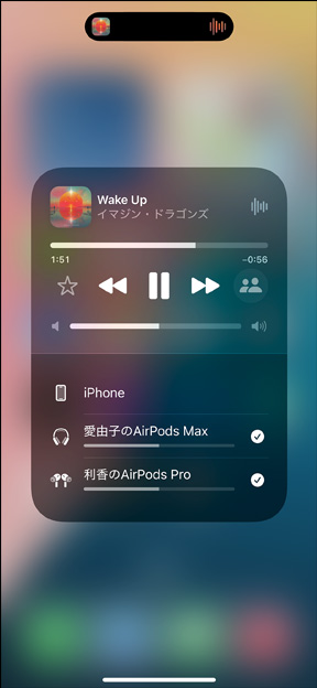 充電ケースに入ったAirPods Pro 2がiPhoneの隣にある。iPhoneは2組のAirPodsに接続されており、それぞれの音量調節が表示されている。