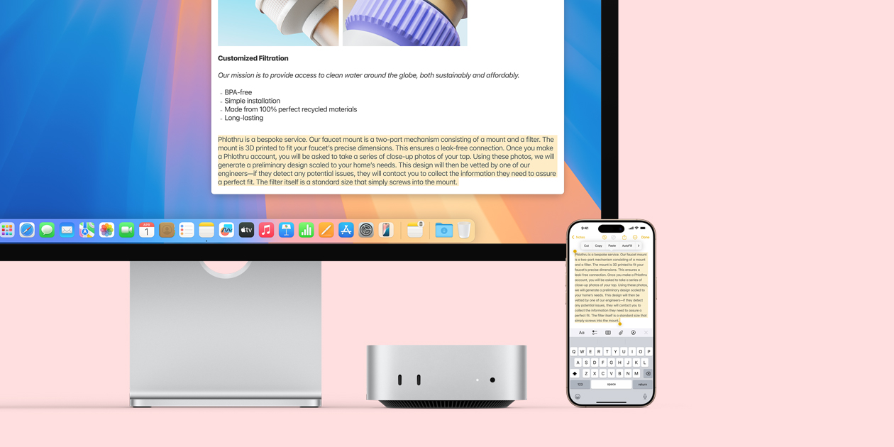 Mac monitor, silver Mac mini, and iPhone placed in a row, with the monitor display and the iPhone screen demonstrating the Universal Clipboard feature of copying and pasting from one Apple device to another