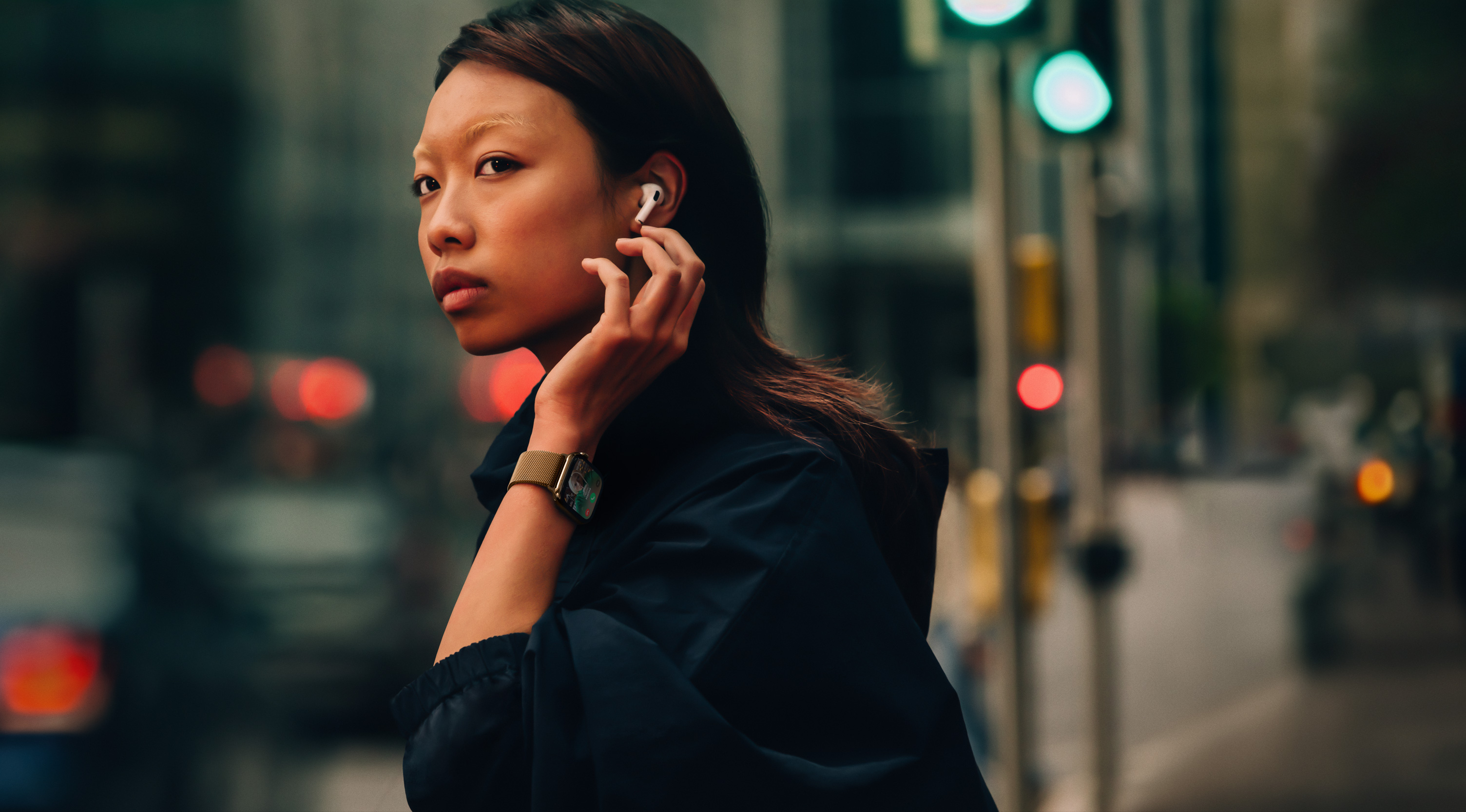 Uma mulher na rua usando o Apple Watch Series 10 e os AirPods.