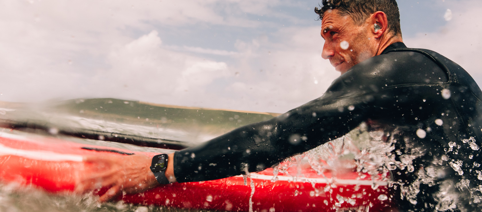 Um homem com uma prancha de standup paddle na água usa um Apple Watch Series 10.