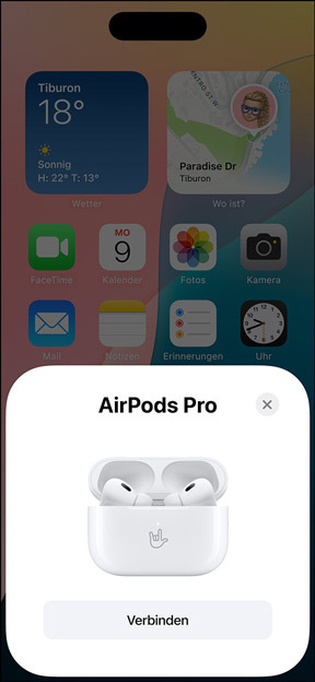 MagSafe Ladecase mit eingesetzten AirPods Pro neben einem iPhone. Eine kleine Kachel auf dem iPhone Homescreen zeigt ein Fenster mit der Taste „Verbinden“, um die AirPods ganz einfach per Fingertipp zu verbinden.