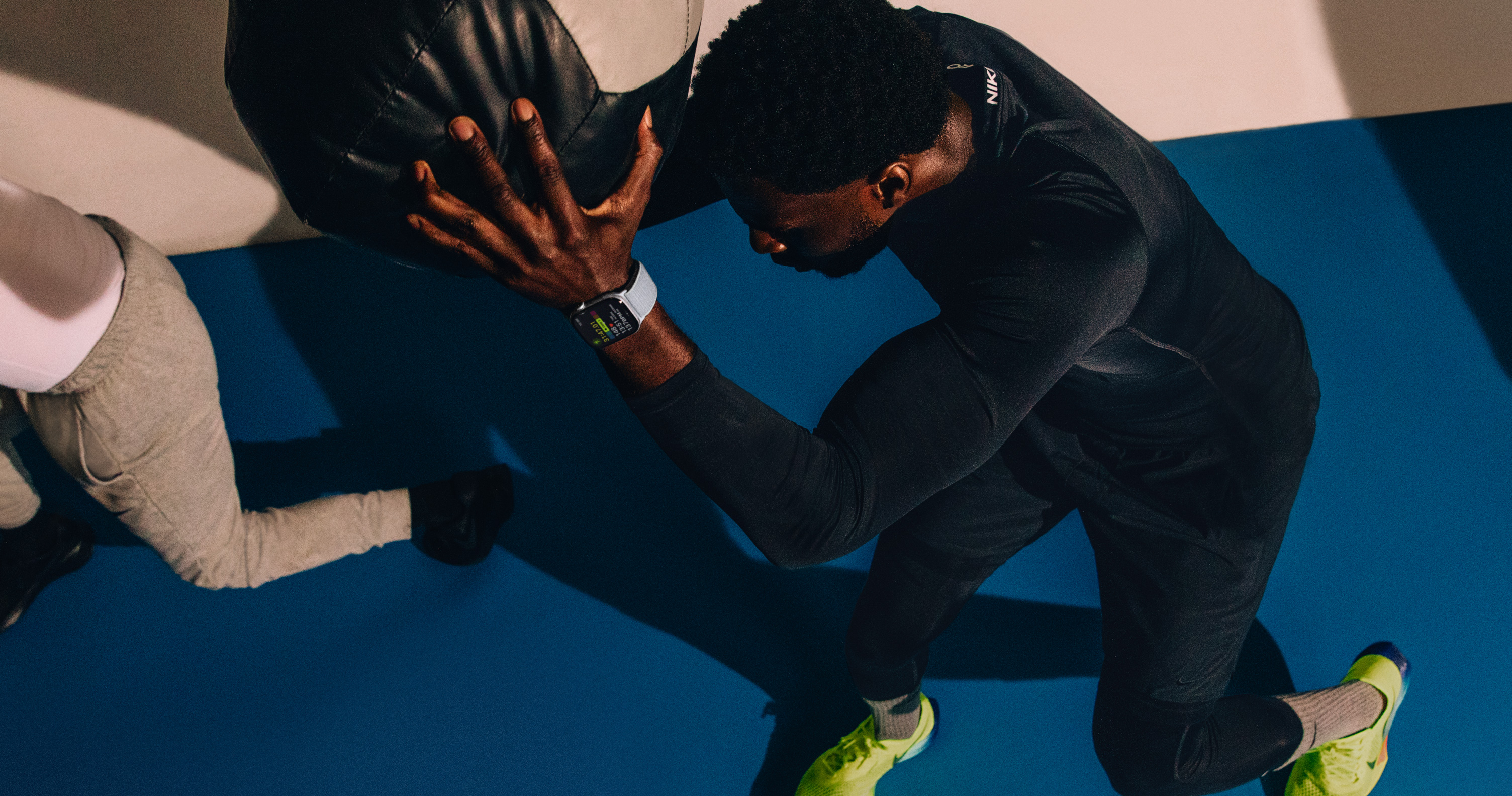 A man working out with a medicine ball while wearing Apple Watch Series 10.