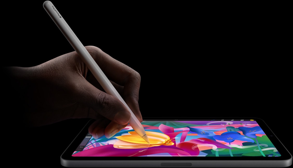 Une main tenant un Apple Pencil Pro réalise une illustration colorée sur un iPad mini.