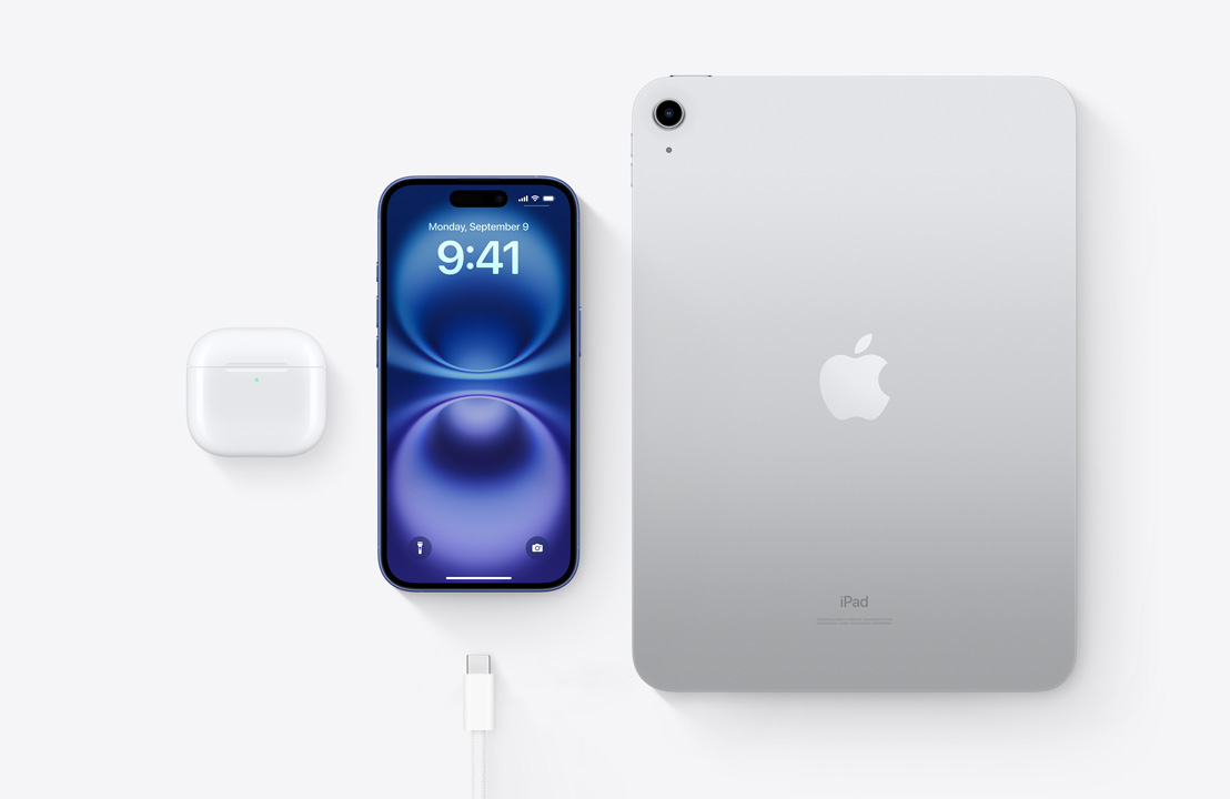 A birds-eye view of AirPods Pro, iPhone 16 and an iPad with a USB-C connector to demonstrate how all three devices can be charged using the same USB-C cable.